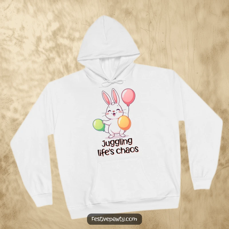 Funny hoodie depicting a delightful rabbit skillfully juggling three brightly colored balloons, offering warmth and playful charm.