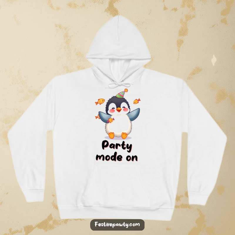 Funny penguin hoodie featuring a fluffy penguin in a party hat juggling fish, perfect for cozy celebrations.