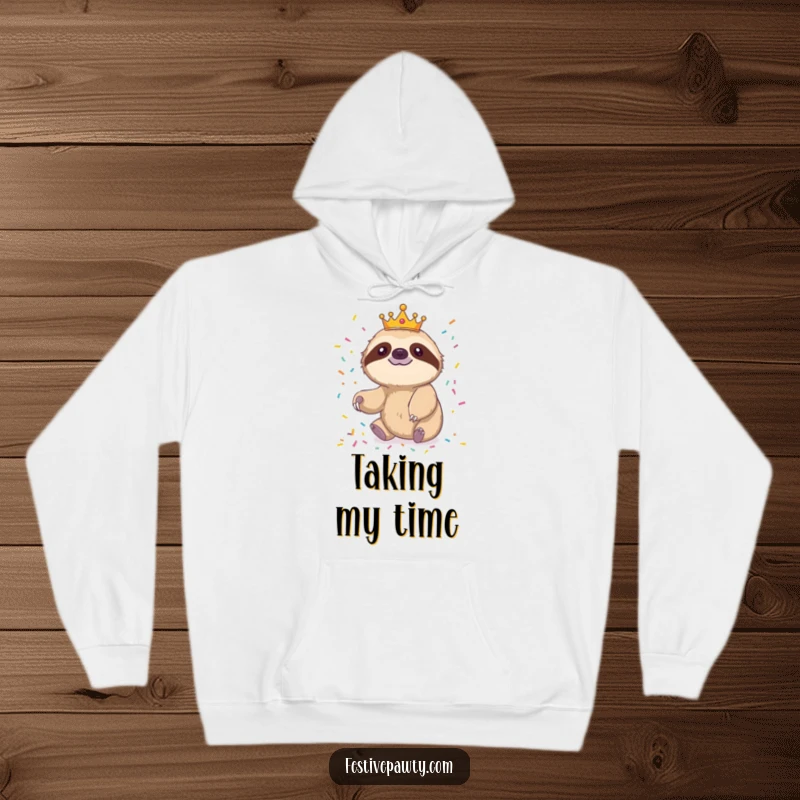 Funny sloth hoodie featuring a cheerful sloth king in a crown, slowly reaching for confetti, perfect for relaxation.
